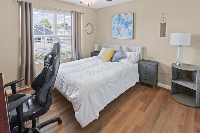 bedroom with wood finished floors, baseboards, and a desk