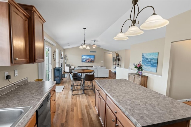 kitchen with dishwasher, a chandelier, light wood-style floors, vaulted ceiling, and a kitchen island
