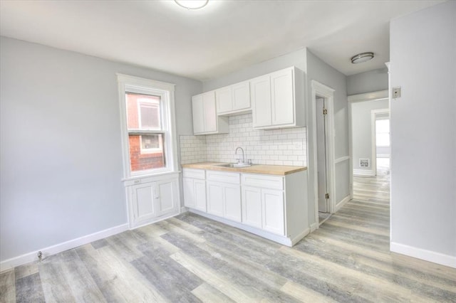 5027 S Broadway Ave Unit 1-4, Saint Louis, MO 63111 - kitchen with a sink, light wood finished floors, backsplash, and baseboards