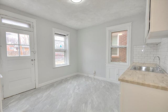5027 S Broadway Ave Unit 1-4, Saint Louis, MO 63111 - unfurnished dining area featuring a sink, baseboards, and light marble finish flooring