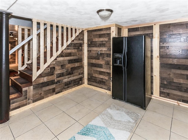 584 Watch Hill Rd, Collinsville, IL 62234 - kitchen featuring black fridge with ice dispenser, wood walls, and tile patterned flooring