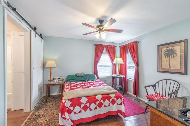700 E S Main St, Dexter, MO 63841 - bedroom with a barn door, wood finished floors, ceiling fan, and baseboards
