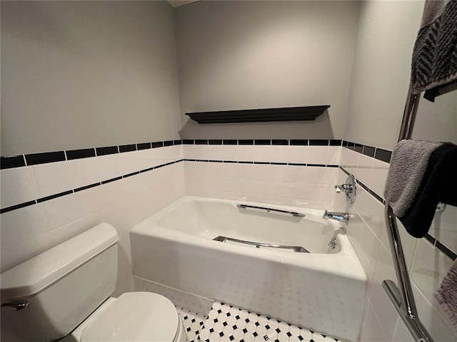 16 Siesta Dr, Hannibal, MO 63401 - full bathroom featuring tile walls, toilet, a bath, and wainscoting