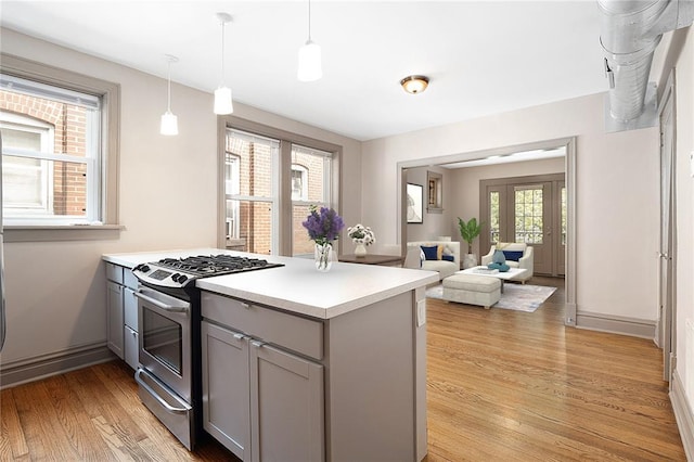 4932 Mardel, Saint Louis, MO 63109 - kitchen with stainless steel gas stove, gray cabinets, a peninsula, light wood-style flooring, and light countertops