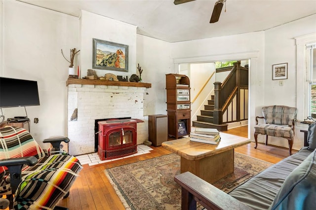 7511 Milan Ave, University City, MO 63130 - living room with hardwood / wood-style floors, a ceiling fan, a wood stove, and stairs