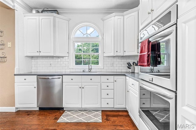 113 Riverwalk Dr, Desloge, MO 63628 - kitchen featuring stainless steel appliances, a sink, dark wood-style flooring, backsplash, and crown molding