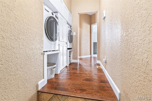 113 Riverwalk Dr, Desloge, MO 63628 - corridor featuring stacked washing machine and dryer, a textured wall, dark wood-style floors, and baseboards