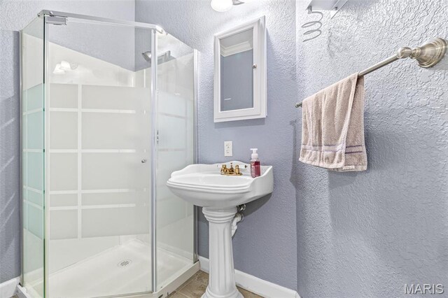 113 Riverwalk Dr, Desloge, MO 63628 - bathroom with a stall shower, a textured wall, and baseboards