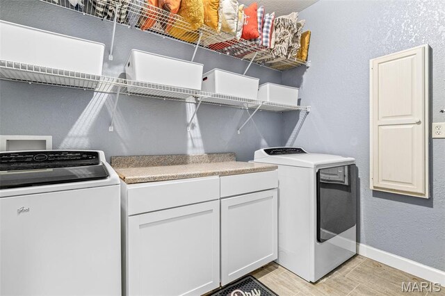 113 Riverwalk Dr, Desloge, MO 63628 - laundry room with light wood-type flooring, washer and clothes dryer, baseboards, cabinet space, and a textured wall