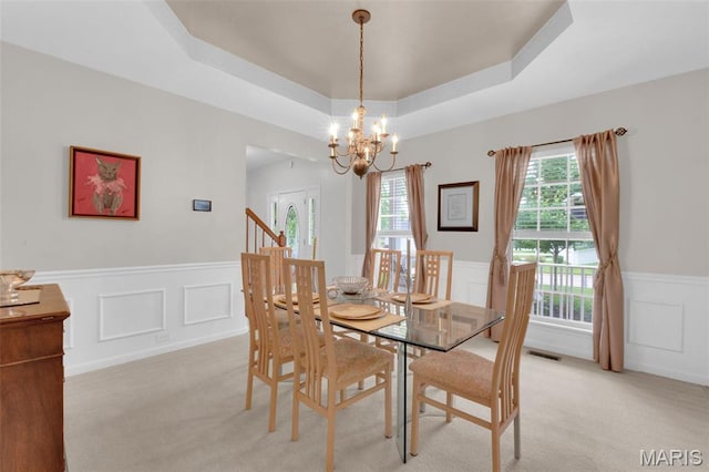 2654 Breckenridge Cir, Ofallon, MO 63368 - dining room featuring a wainscoted wall, a tray ceiling, a chandelier, a decorative wall, and light carpet