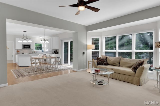 2654 Breckenridge Cir, Ofallon, MO 63368 - living area with a ceiling fan, a chandelier, light wood finished floors, and baseboards