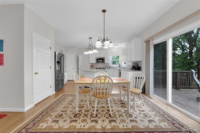 2654 Breckenridge Cir, Ofallon, MO 63368 - dining room with a chandelier, light wood finished floors, and baseboards