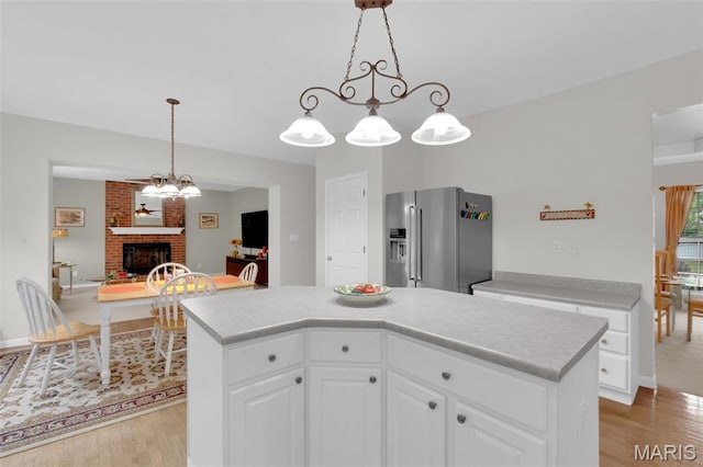 2654 Breckenridge Cir, Ofallon, MO 63368 - kitchen with high end fridge, light wood-style floors, a brick fireplace, and light countertops