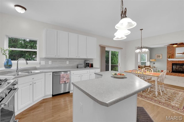 2654 Breckenridge Cir, Ofallon, MO 63368 - kitchen with stainless steel appliances, a sink, light wood-type flooring, light countertops, and a center island