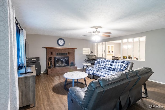 24506 State Road A, Richland, MO 65556 - living room with wood finished floors, a ceiling fan, baseboards, a textured ceiling, and a fireplace
