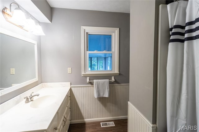 24506 State Road A, Richland, MO 65556 - full bathroom featuring wainscoting, vanity, wood finished floors, and a shower with shower curtain