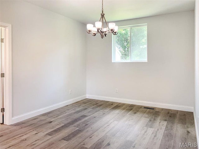 526 State St, Dupo, IL 62239 - empty room with a chandelier, wood finished floors, and baseboards