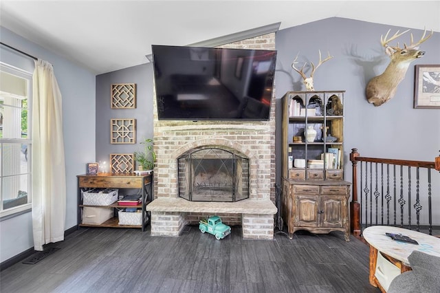 7172 Briarwood Dr, Cedar Hill, MO 63016 - living room with vaulted ceiling, dark wood-style flooring, a brick fireplace, and baseboards
