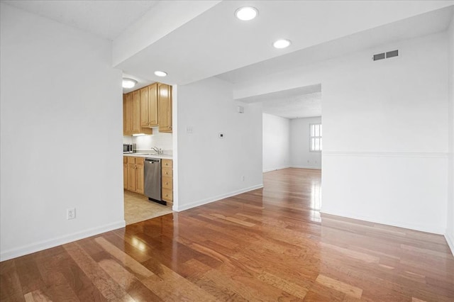 1721 Blue Jay Cv, Saint Louis, MO 63144 - unfurnished living room featuring light wood finished floors, baseboards, recessed lighting, and a sink
