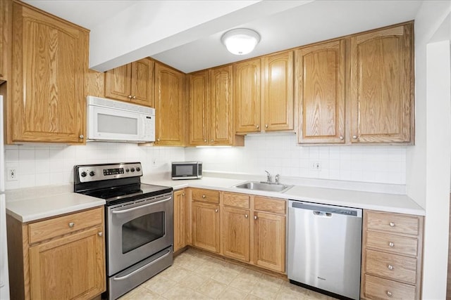 1721 Blue Jay Cv, Saint Louis, MO 63144 - kitchen featuring stainless steel appliances, a sink, tasteful backsplash, and light countertops