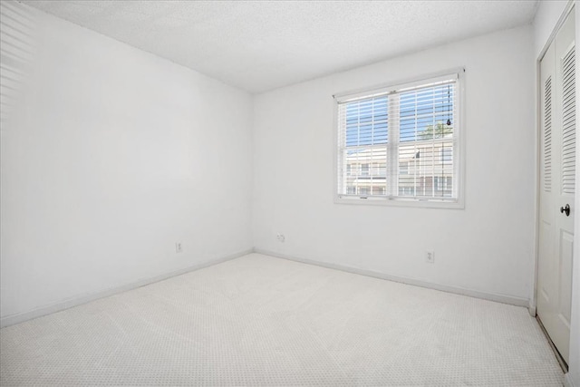 1721 Blue Jay Cv, Saint Louis, MO 63144 - unfurnished bedroom with light carpet, a closet, a textured ceiling, and baseboards