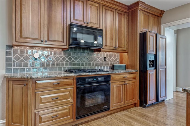 146 N Bemiston Ave, Clayton, MO 63105 - kitchen featuring black appliances, backsplash, light stone countertops, and brown cabinets