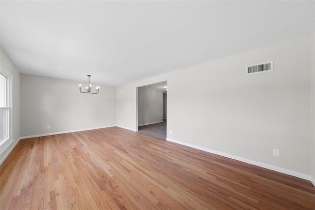 1865 Shardell Dr, Spanish Lake Township, MO 63138 - spare room with a chandelier, light wood-type flooring, and baseboards