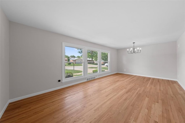 1865 Shardell Dr, Spanish Lake Township, MO 63138 - spare room featuring a chandelier, light wood-style flooring, and baseboards