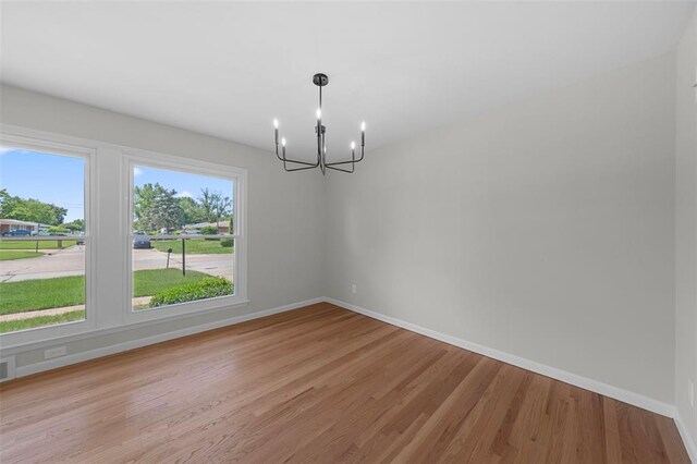 1865 Shardell Dr, Spanish Lake Township, MO 63138 - spare room featuring a chandelier, plenty of natural light, light wood finished floors, and baseboards