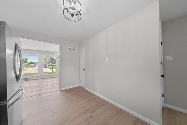 1865 Shardell Dr, Spanish Lake Township, MO 63138 - interior space featuring freestanding refrigerator, light wood finished floors, baseboards, and a chandelier