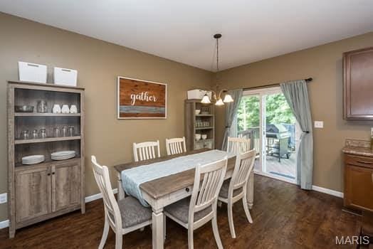 538 Springhurst Pkwy, Ofallon, MO 63368 - dining space featuring a chandelier, baseboards, and dark wood-type flooring