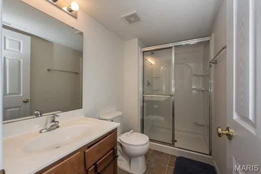 538 Springhurst Pkwy, Ofallon, MO 63368 - bathroom featuring tile patterned floors, vanity, toilet, and a shower stall