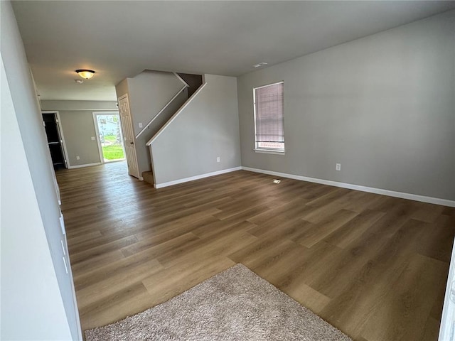 3624 Market St, Saint Louis, MO 63115 - unfurnished living room featuring stairway, baseboards, and wood finished floors