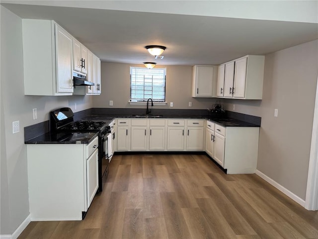 3624 Market St, Saint Louis, MO 63115 - kitchen with black gas range oven, a sink, dark wood-style flooring, and exhaust hood