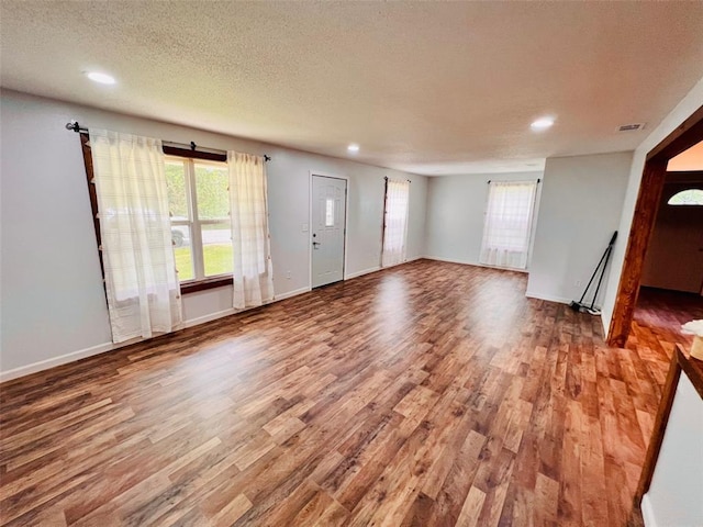 108 Gray St, Sullivan, MO 63080 - unfurnished living room with wood finished floors, recessed lighting, healthy amount of natural light, a textured ceiling, and baseboards