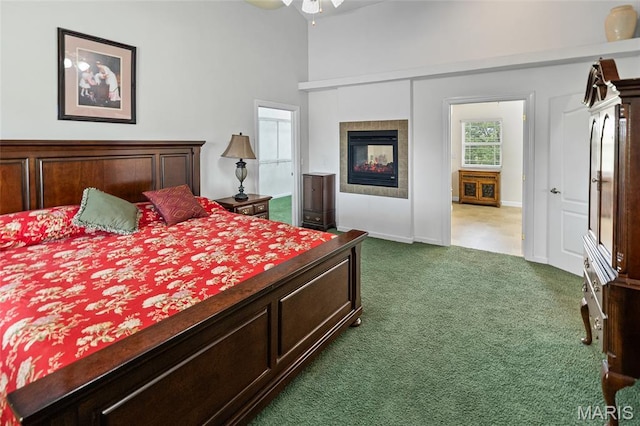 6517 Augies Way Pl, Millstadt, IL 62260 - bedroom featuring dark carpet, a tiled fireplace, a ceiling fan, and a towering ceiling