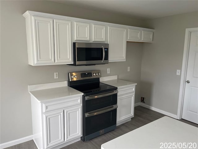 14 Mandy Ct, Troy, MO 63379 - kitchen featuring stainless steel appliances, dark wood finished floors, white cabinets, light countertops, and baseboards