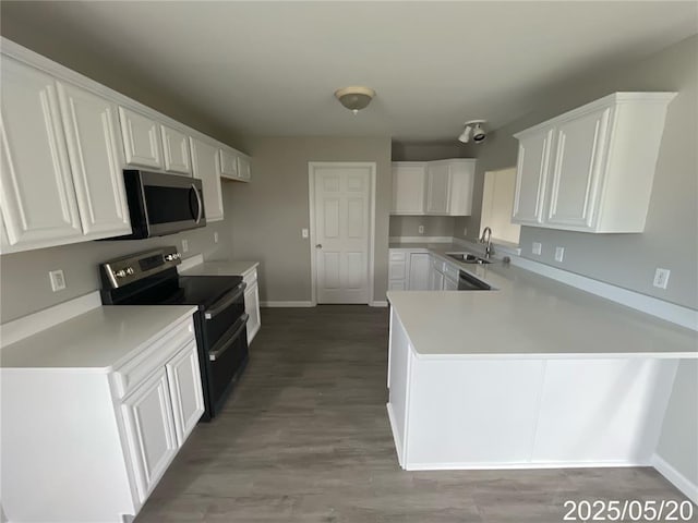 14 Mandy Ct, Troy, MO 63379 - kitchen with appliances with stainless steel finishes, a sink, a peninsula, white cabinetry, and baseboards