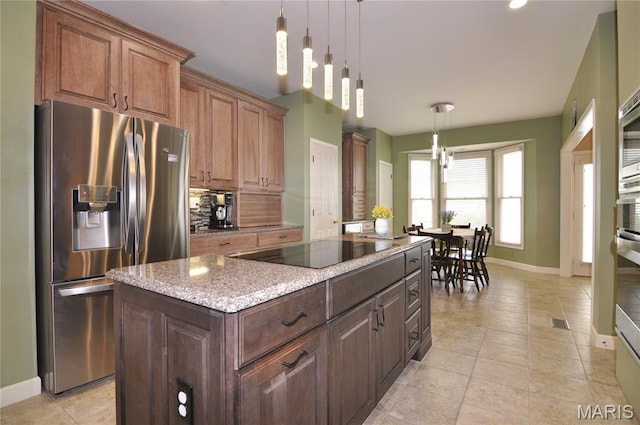 15 Eagles Way Ln, Lake St Louis, MO 63367 - kitchen with stainless steel fridge, black electric stovetop, backsplash, a center island, and light stone counters