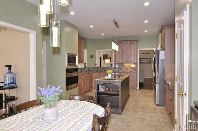 15 Eagles Way Ln, Lake St Louis, MO 63367 - kitchen featuring appliances with stainless steel finishes, recessed lighting, backsplash, a center island, and hanging light fixtures