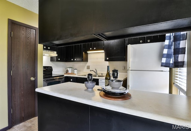 2223 Highland Hill Drive E, Saint Peters, MO 63376 - kitchen featuring electric range oven, freestanding refrigerator, under cabinet range hood, dark cabinetry, and light countertops