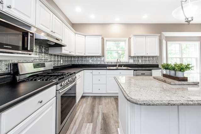 3 Wedgewood Ct, Edwardsville, IL 62025 - kitchen with appliances with stainless steel finishes, under cabinet range hood, a sink, light wood finished floors, and white cabinets