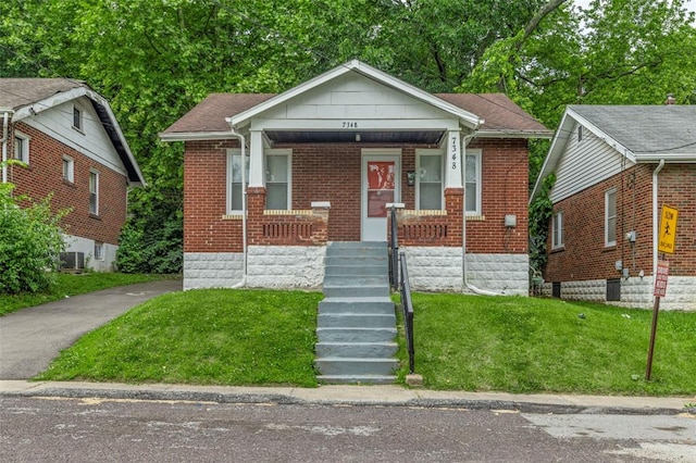7348 Grand Dr, Pagedale, MO 63133 - bungalow-style home with brick siding, a front lawn, and a porch