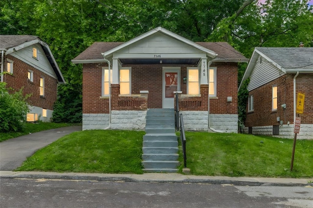 7348 Grand Dr, Pagedale, MO 63133 - bungalow-style home featuring brick siding, a front lawn, and a porch
