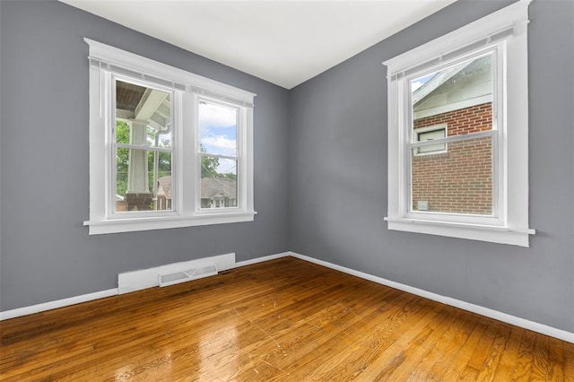 7348 Grand Dr, Pagedale, MO 63133 - empty room featuring plenty of natural light, hardwood / wood-style floors, and baseboards