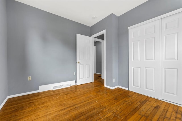 7348 Grand Dr, Pagedale, MO 63133 - unfurnished bedroom with baseboards, a closet, and wood finished floors