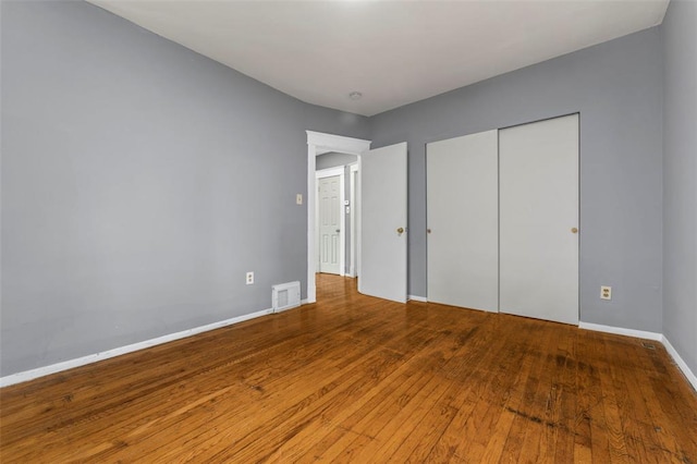 7348 Grand Dr, Pagedale, MO 63133 - unfurnished bedroom with wood finished floors, a closet, and baseboards