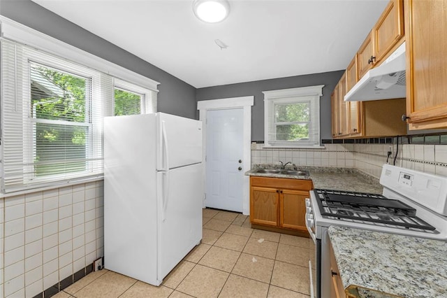 7348 Grand Dr, Pagedale, MO 63133 - kitchen featuring white appliances, under cabinet range hood, a sink, and healthy amount of natural light