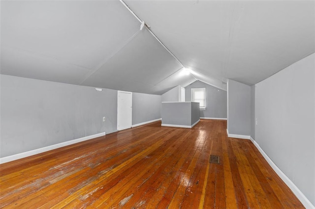 7348 Grand Dr, Pagedale, MO 63133 - additional living space featuring lofted ceiling, hardwood / wood-style floors, and baseboards