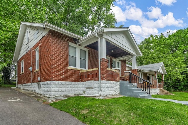 7348 Grand Dr, Pagedale, MO 63133 - view of front of property featuring a porch, brick siding, and a front yard